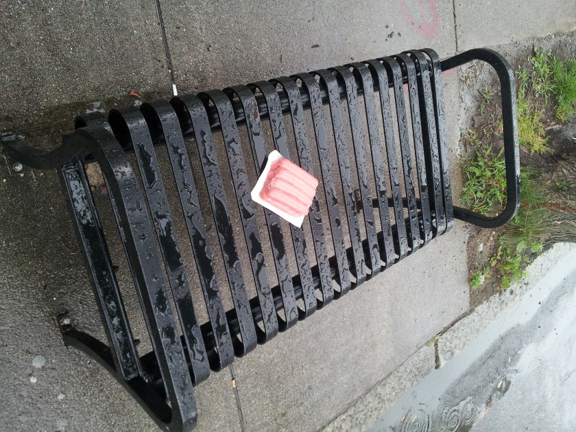 Hotdogs on the bench at the bus stop.